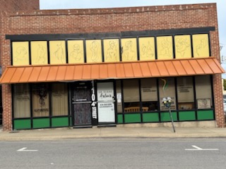 Front view of Aslanis Acupuncture building with orange awning and glass storefront