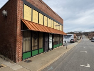 Corner view of brick building housing Aslanis Acupuncture on a downtown street